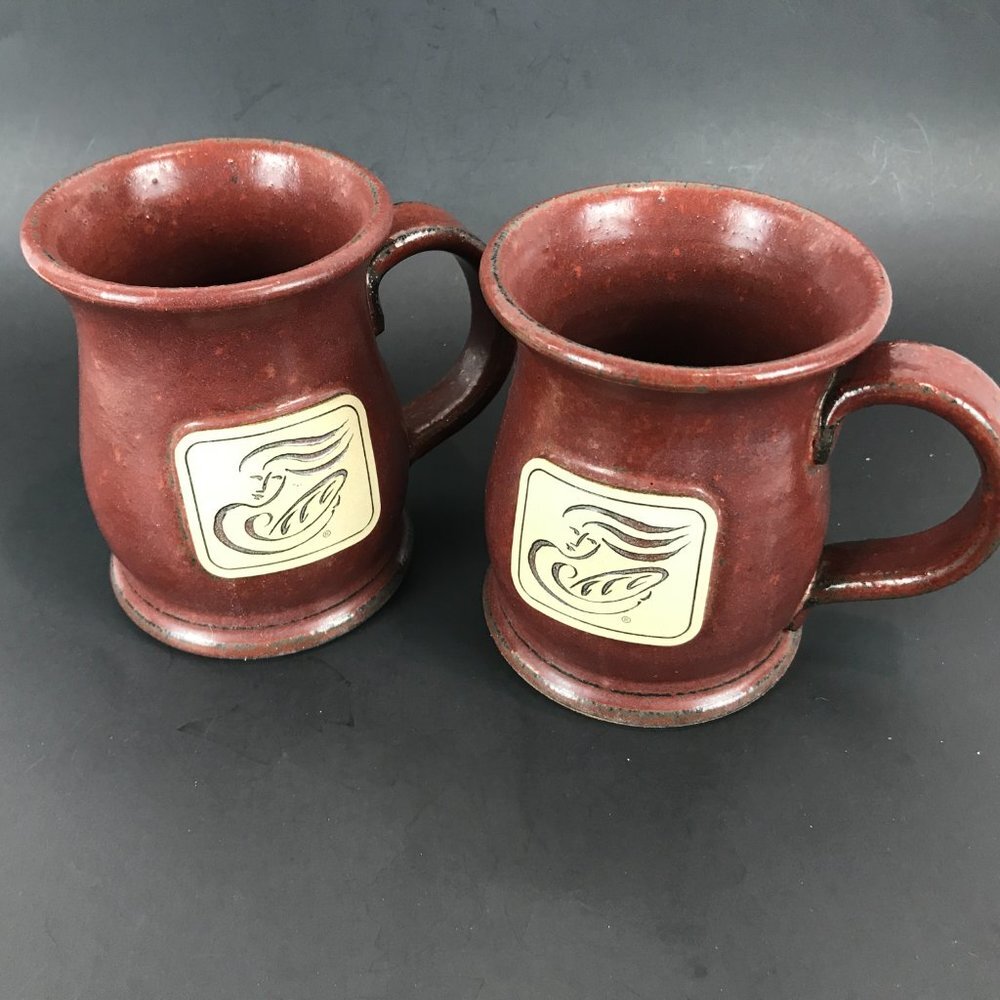 Set of two art pottery mugs, signed